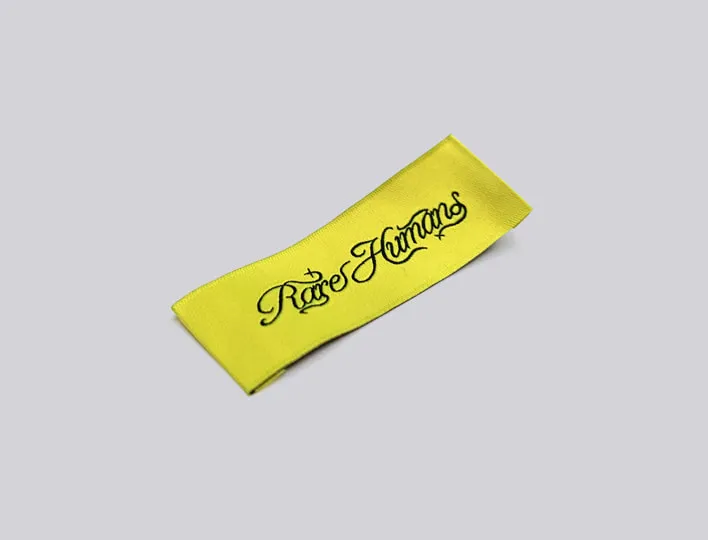 Yellow end-folded woven clothing label.