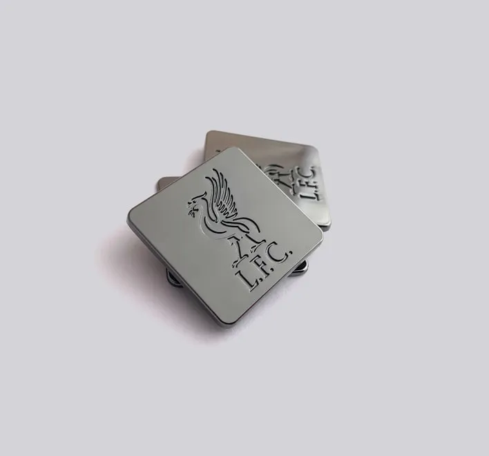 Engraved metal machine applied badge
